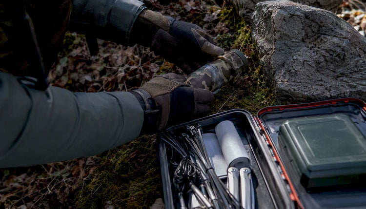 Draußen werden Geocaches von einer helfenden Hand gewartet und gepflegt.