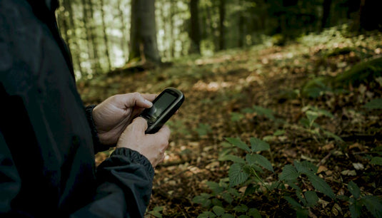 Jemand bedient ein GPS-Gerät im Stadtpark.