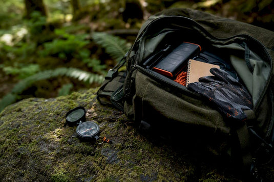 Teilweise geöffneter Geocaching-Rucksack mit Ausrüstung