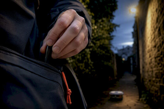 Geocacher fühlt im Dunkeln nach seiner Tasche am Körper