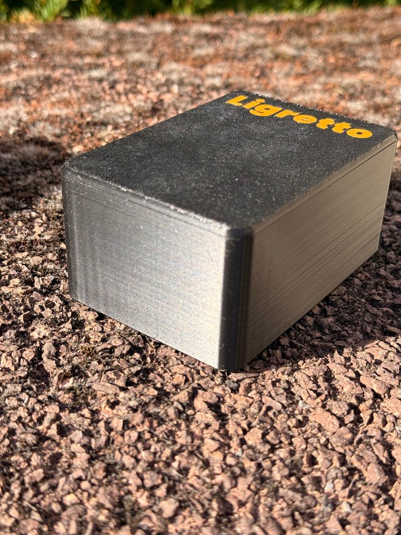 Laden Sie das Bild in Galerie -Viewer, CacheWerk GameBox für Ligretto – geschlossene schwarze Kartenbox mit orangefarbener Beschriftung in liegender Ansicht
